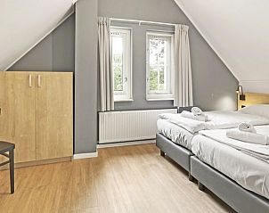 Slaapkamer met twee eenpersoonsbedden en uitzicht in Landgoed De Elsgraven bungalow in Enter, Twente.