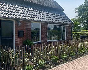 Voorkant van Vakantiehuisje in Daarle, Twente, met gezellige tuin en hek.