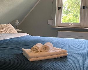 Stijlvolle decoratie in Vakantiehuisje in Daarle, Twente, met spiegel en vaas.