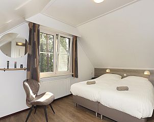 Knusse slaapkamer in Boshuus Comfort, Deurningen, Twente, met uitzicht op de natuur, ideaal voor een rustgevende vakantiehuiservaring.