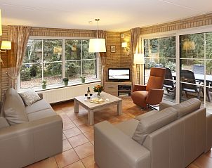 Gezellige woonkamer in Boshuus Comfort vakantiehuis, Deurningen, met uitzicht op de natuur.