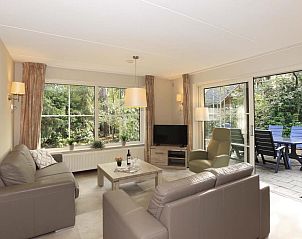 Gezellige woonkamer in Boshuus Comfort Plus vakantiehuis in Deurningen, Twente, met uitzicht op de groene natuur.