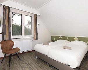 Gezellige tweepersoons slaapkamer met uitzicht op de tuin in Boshuus XL Wellness vakantiehuis Deurningen.