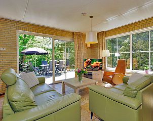 Ruime woonkamer met terraszicht in Boshuus XL Wellness vakantieaccommodatie in Deurningen, Twente.