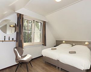 Lichte slaapkamer met uitzicht op de natuur in Boshuus Zorg vakantiehuis, Deurningen, Twente.