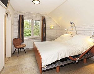 Lichte slaapkamer met groot raam in Boshuus Zorg, vakantieaccommodatie in Deurningen, Overijssel.