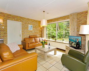 Gezellige woonkamer van Boshuus Wellness vakantiehuis in Deurningen, Twente, met comfortabele zithoek en uitzicht op de natuur.