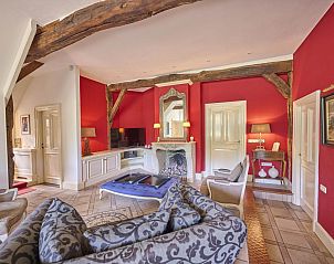 Gezellige woonkamer van Erve Het Klaashuis vakantiehuis in Deurningen, Twente, met authentieke houten balken en warme inrichting.