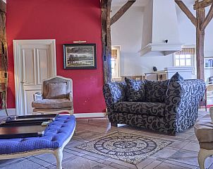 Gezellige woonkamer in vakantiehuis Erve Het Klaashuis, Deurningen, Twente, met comfortabele banken en landelijke charme.