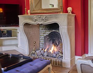 Gezellige open haard in de woonkamer van Erve Het Klaashuis, een vakantiehuis in Deurningen, Twente, Overijssel.