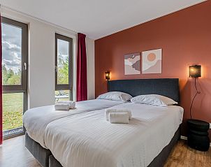 Helles Schlafzimmer im Ferienhaus Sallandse Heuvelrug, Hoge Hexel, mit zwei Betten und Blick auf die Natur.