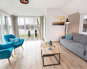 Lichte woonkamer in Twents Buitenverblijf 6, chalet in Hoge Hexel, Twente, met uitzicht op het water.