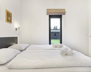 Minimalistische slaapkamer in Sallandse Heuvelrug 4C, Hoge Hexel, met nachtkastje en leeslamp.