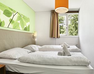 Waschbecken im Badezimmer von Twenhaarsveld 6-Personen-Bungalow 6CE, Holten, mit Handtchern und Spiegel.