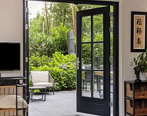 Gezellige binnenruimte van Huisje in Holten met openslaande deuren naar een zonnig terras, gelegen in het groene Salland, Overijssel.