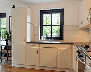 Moderne keuken in Huisje in Holten, een vakantiehuis in het groene Salland, Overijssel, met uitzicht op de tuin vanuit het raam.