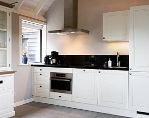 Moderne keuken in Vakantiehuisje in Luttenberg, Salland, Overijssel met strakke witte kasten en een stijlvol interieur voor een comfortabel verblijf.