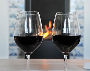 Gezellige sfeer bij de open haard in Vakantiehuis in Hellendoorn, ideaal voor een knusse avond in Salland, Overijssel.