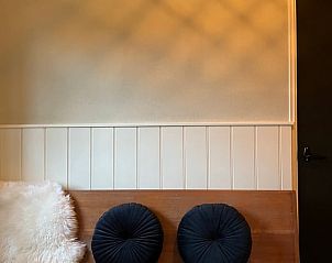 Gemtliche Sitzecke im Cottage in Hellendoorn, einem Ferienhaus in Hellendoorn, Salland, Overijssel mit bequemen Kissen und stimmungsvoller Wand.