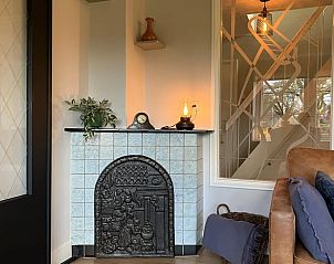 Gemtlicher Innenbereich des Huisje in Hellendoorn, ein Ferienhaus in Salland, Overijssel, mit gemtlichem Kamin und komfortabler Sitzecke.