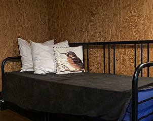 Gemtliches Schlafzimmer im Ferienhaus in Wesepe, Salland, Overijssel, mit komfortabler Sitzecke und dekorativen Kissen.