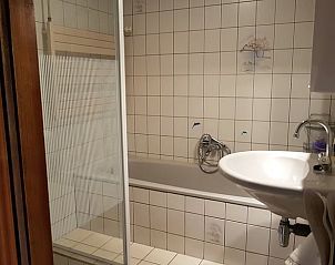 Stilvolles Badezimmer des Ferienhauses in Lettele, ausgestattet mit Badewanne und Dusche.