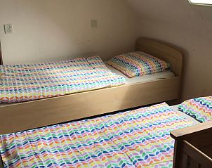 Gemtliches Kinderzimmer im Ferienhaus in Lettele, ausgestattet mit buntem Bettzeug.