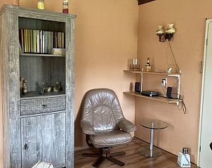 Gemtliche Leseecke im Ferienhaus in Lettele, mit bequemem Sessel und Bcherregal.