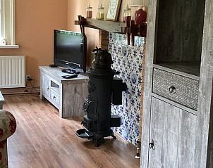 Wohnzimmer des Ferienhauses in Lettele mit authentischem Ofen und modernen Annehmlichkeiten.