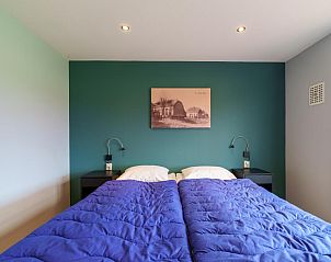 Slaapkamer in Weidezicht A, Marle, met twee eenpersoonsbedden en sfeervolle verlichting.