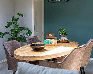 Eettafel in Weidezicht A, vakantiehuis in Marle, omringd door comfortabele stoelen en planten.