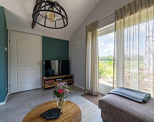 Zithoek in Weidezicht A, Marle, Overijssel met uitzicht op de tuin en comfortabele bank.