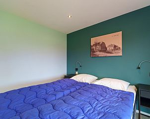 Slaapkamer in Weidezicht A, vakantiehuis in Marle, met comfortabele bedden en wanddecoratie.