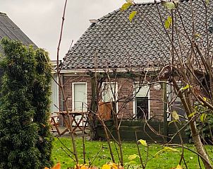 Cottage in Ommen, a charming cottage in the Vecht region, Overijssel, with an inviting terrace and green surroundings.