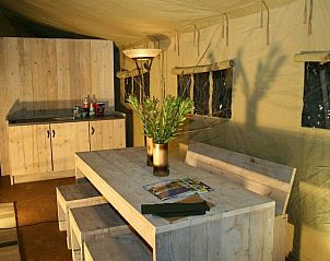 Gezellige binnenruimte van Summer Lodge tenthuis in Beerze, met houten meubels in de Vechtstreek, Overijssel.