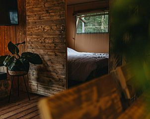 Slaapkamer met een rustgevend uitzicht in Vechtglamping Lodge, Overijssel.
