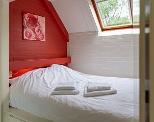 Gezellige slaapkamer met rood accent in Vakantiehuis Buitenplaats Gerner, Dalfsen, Overijssel.