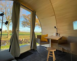 Comfortabele zithoek en eetruimte met uitzicht op de natuur in Huisje in Dalfsen, Overijssel.