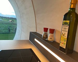 Keuken van Huisje in Dalfsen met kruiden en olijfolie, met uitzicht op groene weiden.