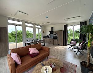 Ruime woonkamer van Just Nature MIVA vakantiewoning in Hardenberg, Overijssel met uitzicht op de natuur.