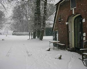 Sneeuw bedekt het terras van Vakantiehuisje in Balkbrug, een sfeervolle vakantiewoning in de winterse natuur van de Vechtstreek, Overijssel.