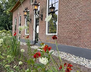 Historische gevel van Vakantiehuis in Balkbrug met kleurrijke bloementuin, Vechtstreek.