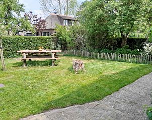 Rustikaler Garten des Ferienhauses OV602 in Giethoorn mit Picknicktisch aus Holz und viel Grn.