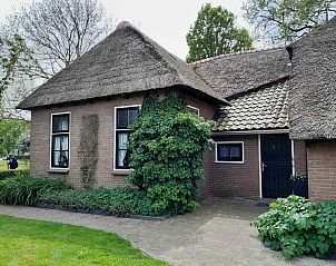 Auenansicht des Ferienhauses OV602 in Giethoorn mit bunten Blumen und grnem Garten.