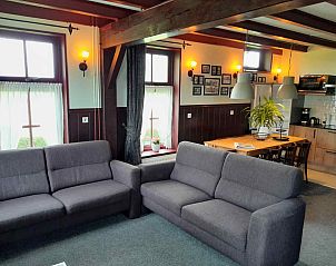 Gemtliches Wohnzimmer im Ferienhaus OV602 in Giethoorn mit Sofas und Holzbalken.