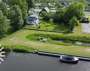 Auenterrasse mit Sonnenschirm am Ferienhaus OV072 in Giethoorn, ideal fr sonnige Tage.