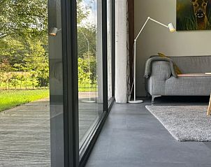 Moderne binnenruimte in Huisje in De Bult met uitzicht op de natuur.