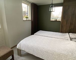 Sfeervolle slaapkamer in Vakantiehuis in Wanneperveen, Noordwest Overijssel, met twee eenpersoonsbedden en rustieke details.
