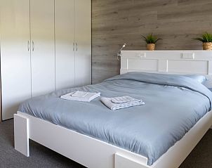 Slaapkamer in Vakantiehuisje in Scheerwolde, Overijssel, met comfortabel bed en rustige sfeer.
