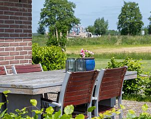 Eetruimte in OV701 vakantiehuis Scheerwolde, Overijssel met kleurrijke servies en jam op tafel.